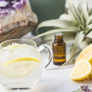 glass of lemonade with crystal, lemons, essential oil and lavender.
