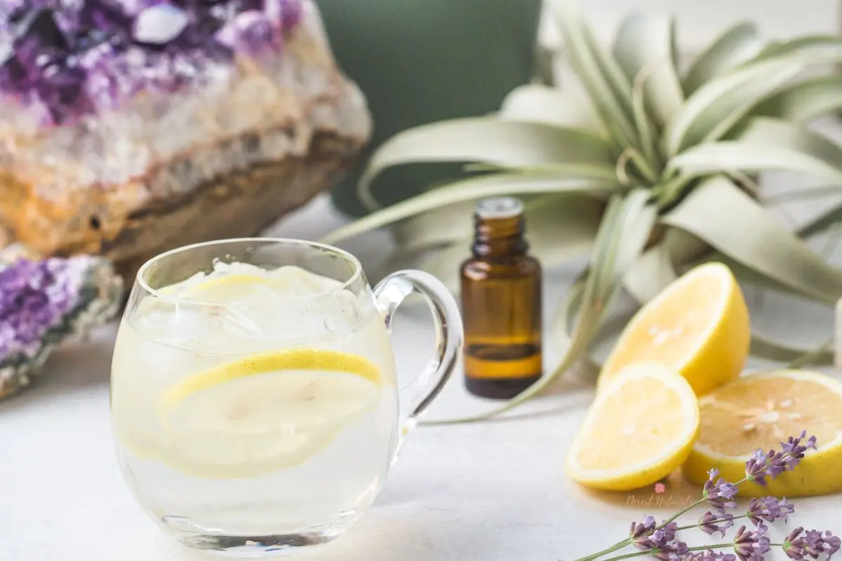 glass of lemonade with crystal, lemons, essential oil and lavender.
