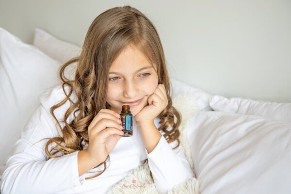 image of girl smelling bottle of doterra breathe essential oil