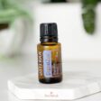 image of bottle of doterra digestzen essential oil with plants in background