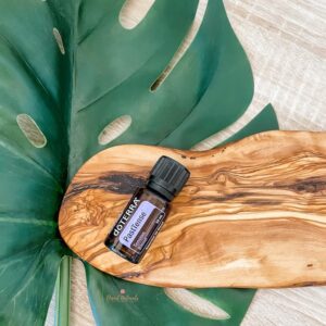 plant leaf with wood and a bottle of doTERRA pasttense essential oil blend
