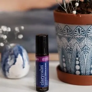 blue and white flower pot in background with bottle of doterra clary calm 10ml roller