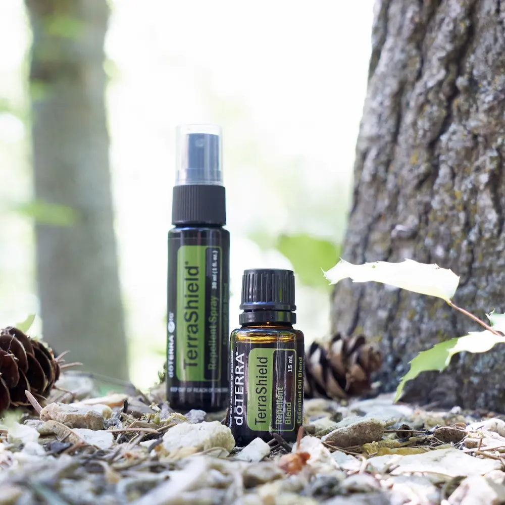 photo of doterra terrashield spray and essential oil bottle in outdoor setting