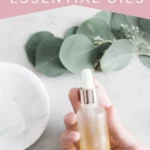 woman's hand holding a dropper bottle of diy face serum with essential oils