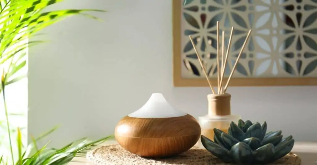 essential oil diffuser on furniture with mirror on wall and houseplant