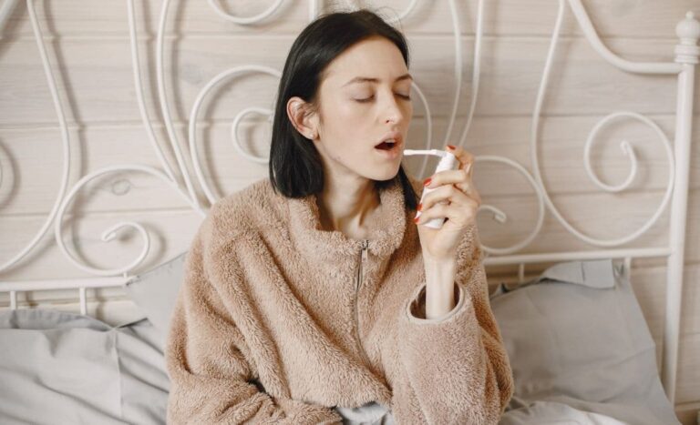 sick woman using a sore throat essential oil spray
