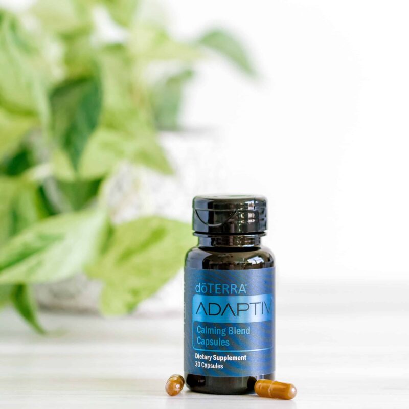 bottle of doterra adaptive capsules with a plant in the background
