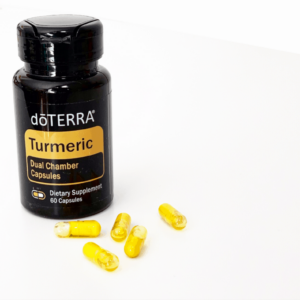white background with bottle of doterra turmeric capsules and several capsules