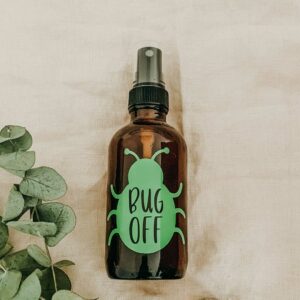 How to make your own essential oil bug spray. glass spray bottle with bug sticker and text that says bug off.