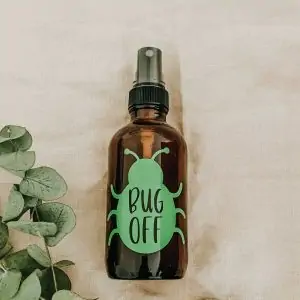 How to make your own essential oil bug spray. glass spray bottle with bug sticker and text that says bug off.