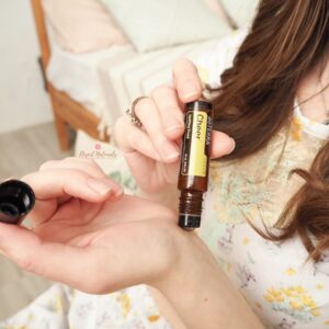 woman apply doterra cheer touch roller to her wrist