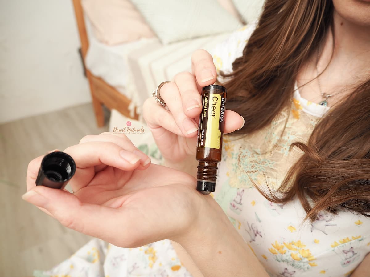 woman apply doterra cheer touch roller to her wrist