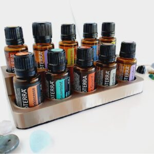2 level essential oil stand with doterra bottles in it on a white background