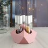 rose gold essential oil roller holder with crystal rollers on counter in front of fairy lights