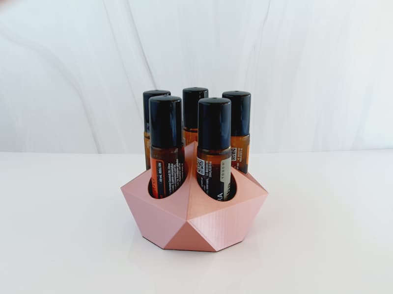 white background with image of small rose gold essential oil roller holder