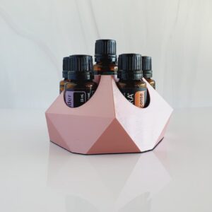 white background with image of small essential oil stand in rose gold