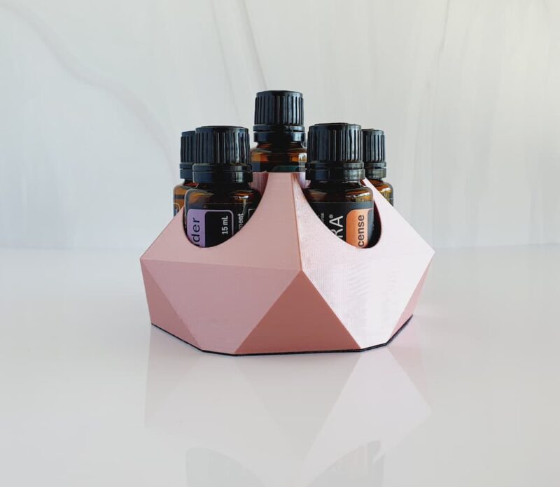white background with image of small essential oil stand in rose gold