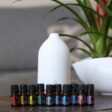 flowers in the background with doterra essential oil bottles and laluz diffuser from the aroma essentials starter kit