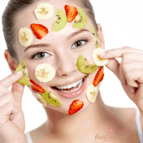 happy woman with slices of mixed fruit on her face