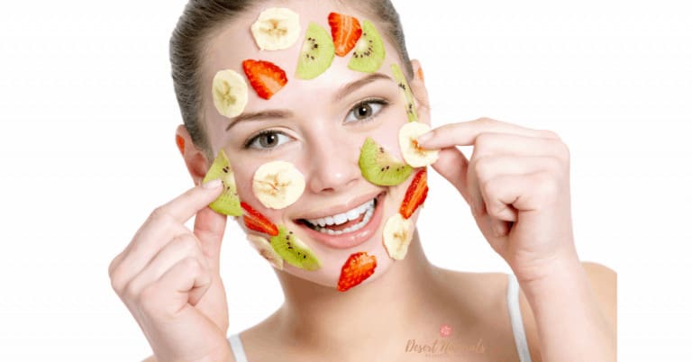 happy woman with slices of mixed fruit on her face