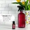 directions for how to make a room spray with doterra citrus bloom with a pink glass spray bottle, bottle of the essential oil and some flowers in the bagkground