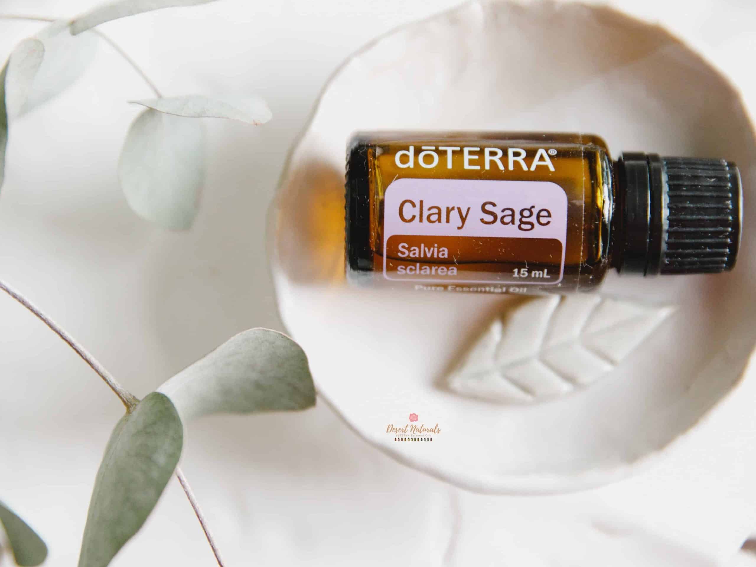 bottle of doterra clary sage on small decorate white plate with green sprig