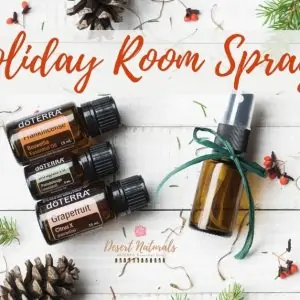 Pine Cones and Pine branches with doterra essential oils and a small spray Bottle with text Holiday Room Sprays