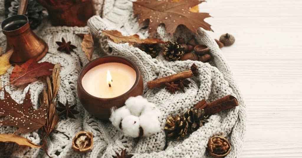 candle and blanket with fall leaves for healthy habits