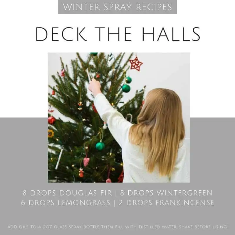 a girl decorating a Christmas tree with an essential oil spray recipe