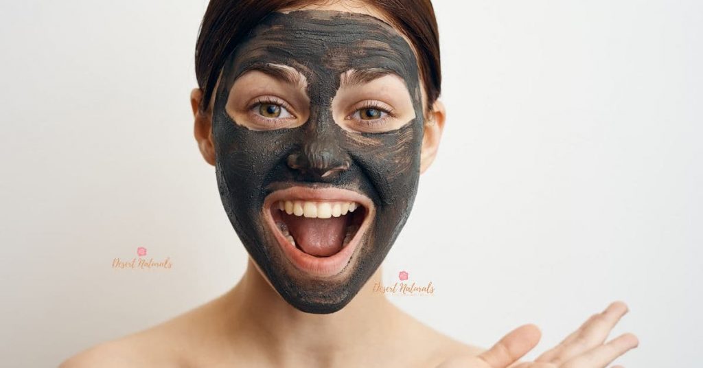 white background with woman laughing with a diy charcoal face mask on