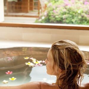 woman taking a diy detox bath with essential oils in a beautiful bathtub
