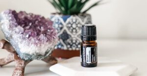 bottle of doterra roman chamomile essential oil with amethyst crystal