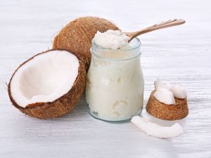 coconuts plus jar of coconut oil with spoon for oil pulling