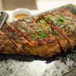 a grilled steak with parsley on it and a steak knife
