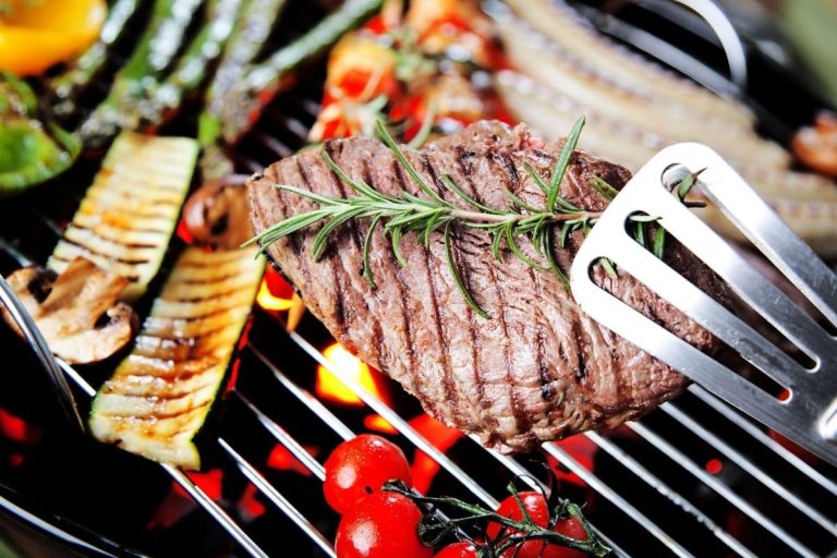 meat and vegetables being grilled on the barbeque