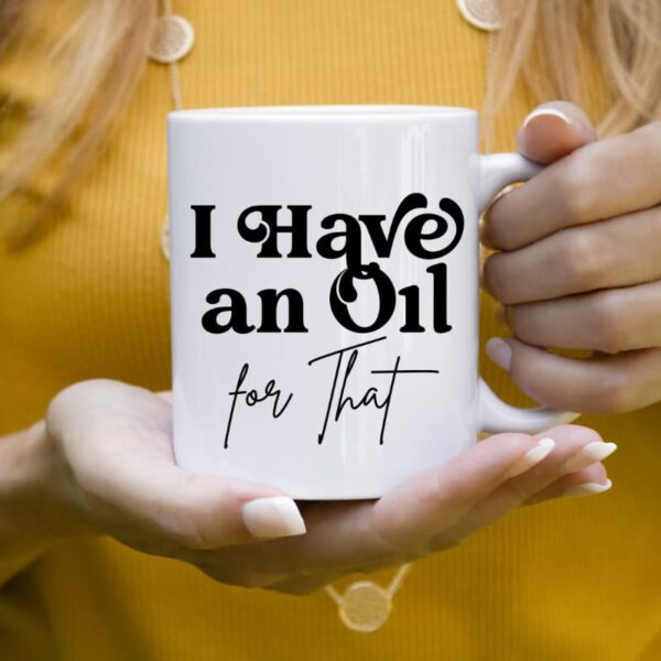 woman in yellow shirt holding a mug that says I Have an Oil For That essential oil mug