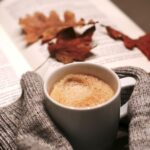 image of autumn leaves, sweater arms and coffee