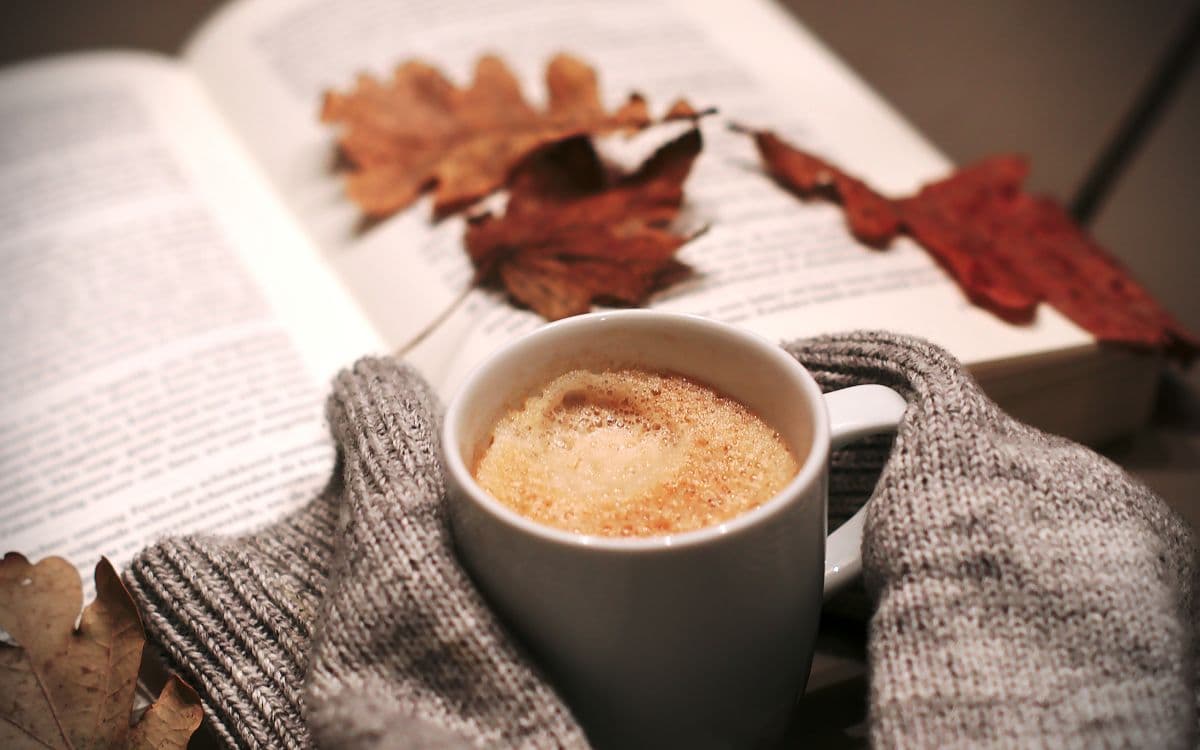 image of autumn leaves, sweater arms and coffee