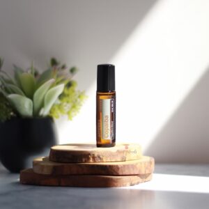 product image of doTERRA copaiba touch on stacks of wood rounds and a plant