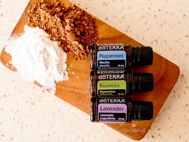 wood board with arrowroot powder, cocoa powder and doterra essential oils for making dry shampoo