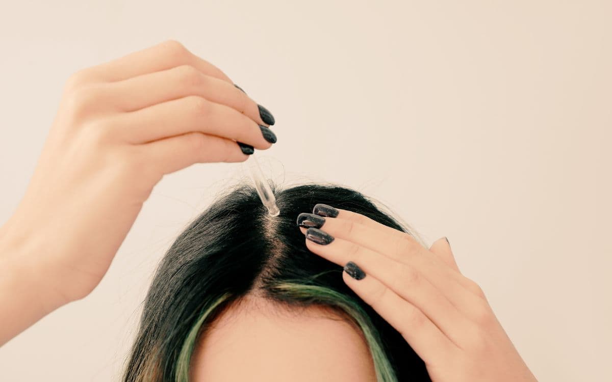 woman apply diy essential oil hair growth serum to scalp