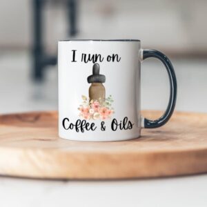 image of coffee mug with black handle on wooden board with I run on coffee and oils