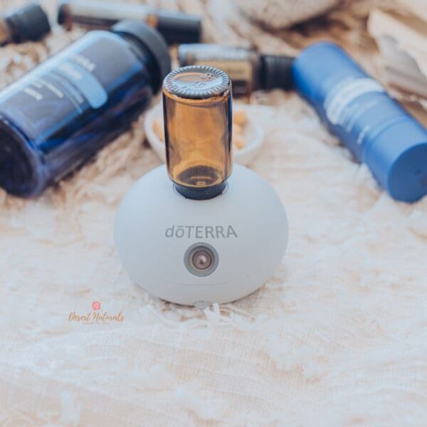 photo of doterra bubble diffuser with essential oil bottle and deep blue products in background