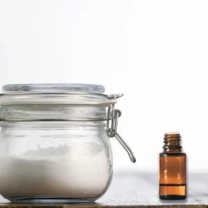 jar of homemade soft scrub natural cleaner with essential oil bottle
