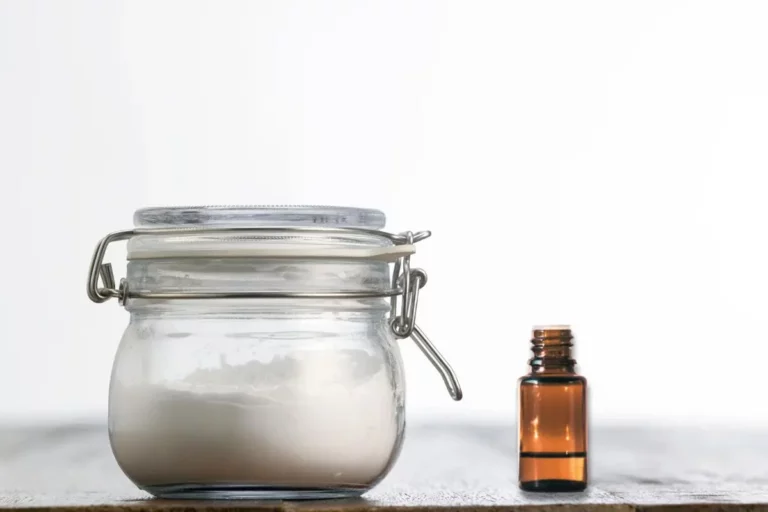 jar of homemade soft scrub natural cleaner with essential oil bottle