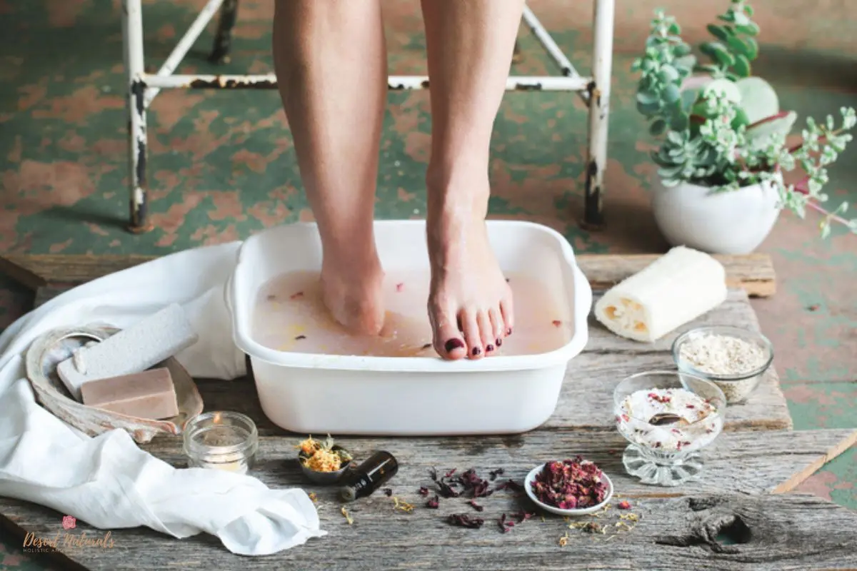 woman's feet in detox bath with dried florals and essential oils