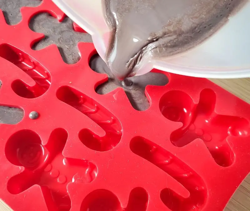 image of melt and pour soap being poured into gingerbread man molds