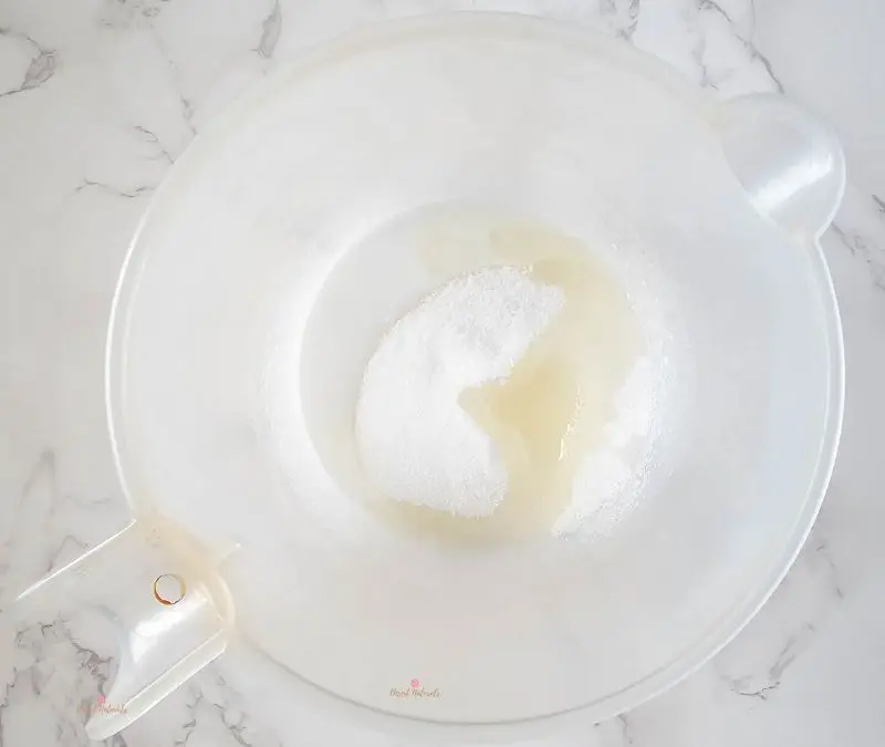 image of adding sugar and almond oil to the melted soap base for making diy rose sugar scrub bars.