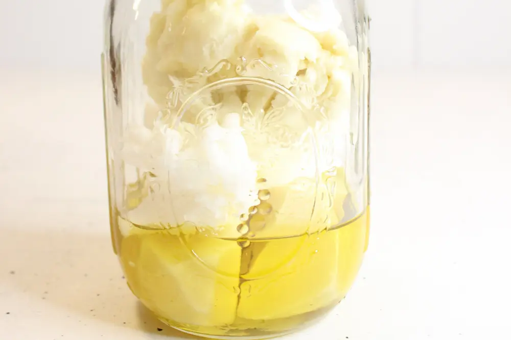 image of melting the ingredients in a glass mason jar for diy body butter