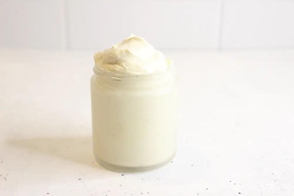 homemade diy oatmeal body butter in a glass jar on the counter.